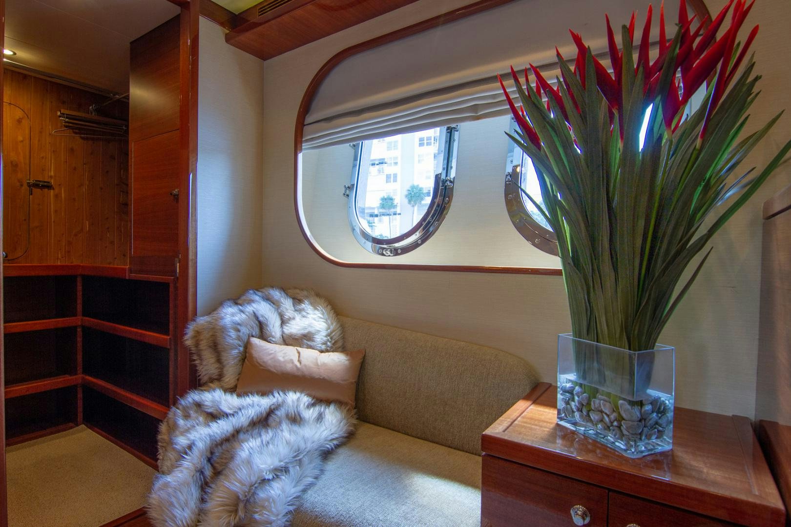 a dog sitting on a couch looking at a vase with flowers aboard BRAVO Yacht for Sale