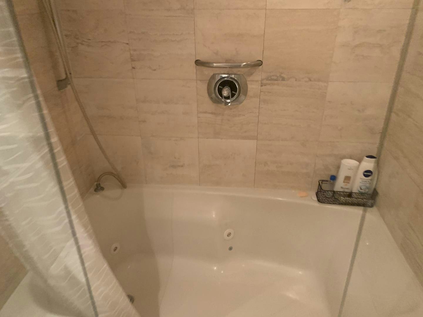 a bathtub with a shower head aboard REHAB Yacht for Sale