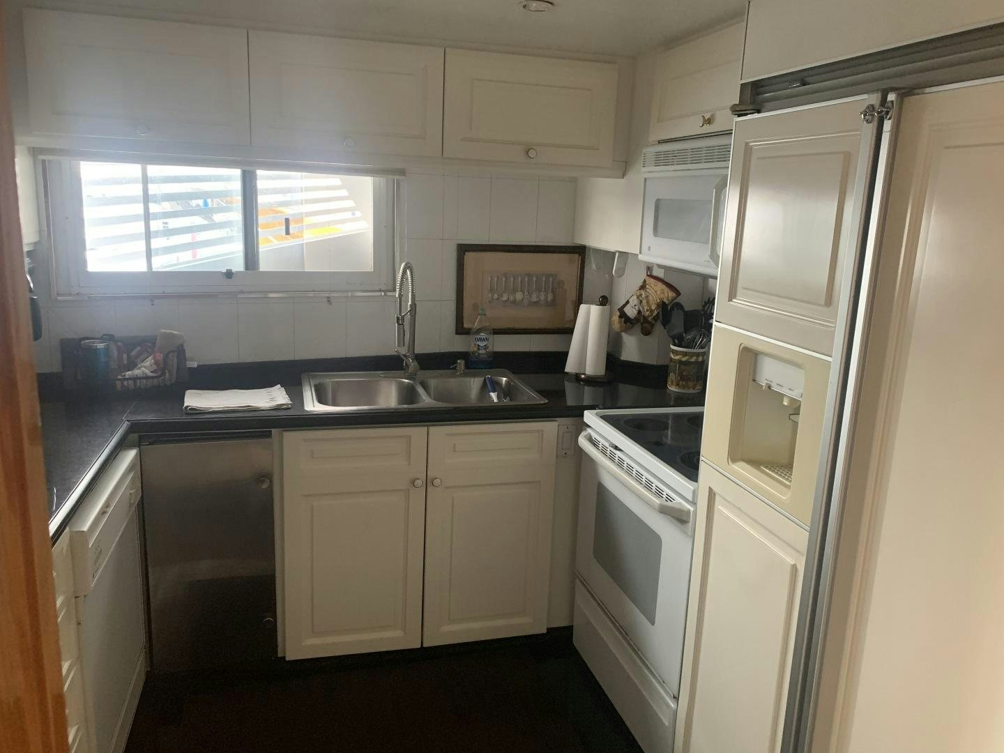a kitchen with white cabinets aboard REHAB Yacht for Sale