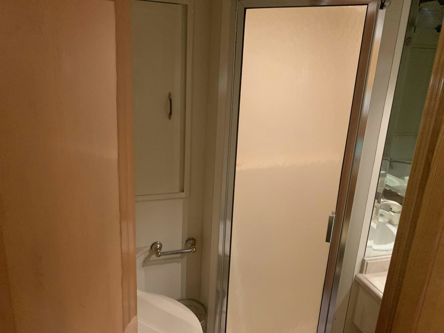 a bathroom with a toilet and a door aboard REHAB Yacht for Sale