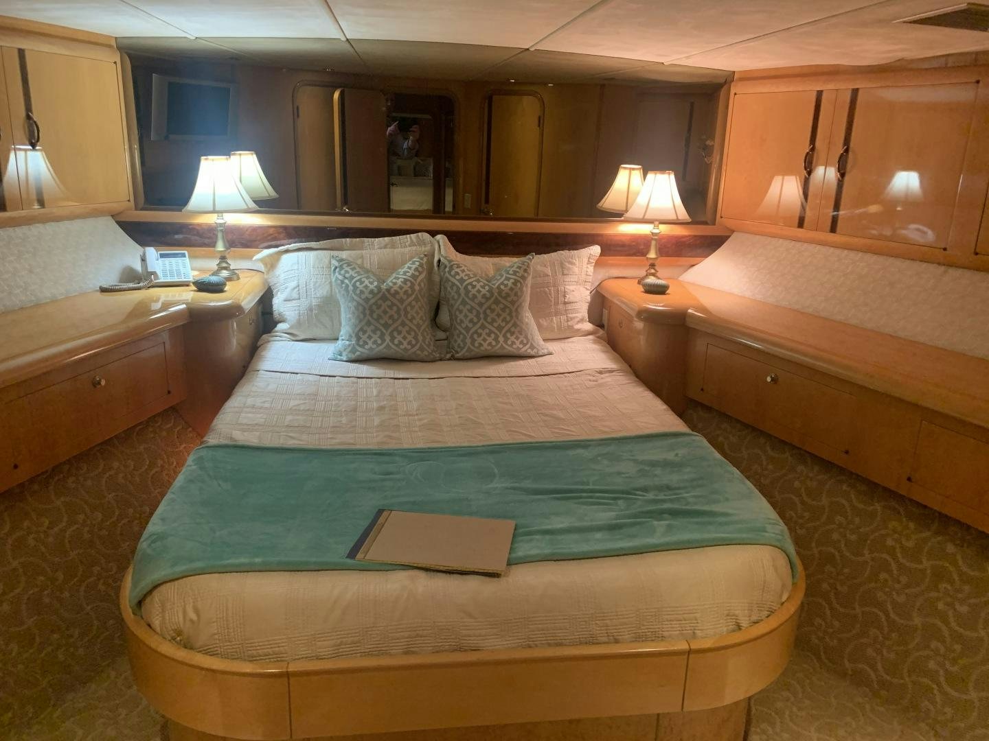 a bed with pillows and a book aboard REHAB Yacht for Sale
