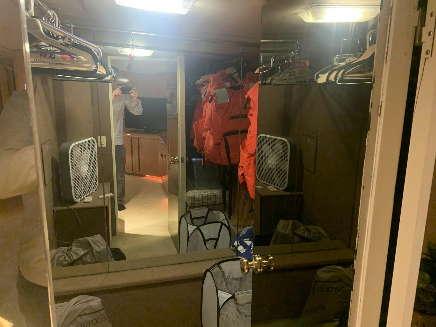 a person taking a picture of a room with a mirror and clothes aboard REHAB Yacht for Sale