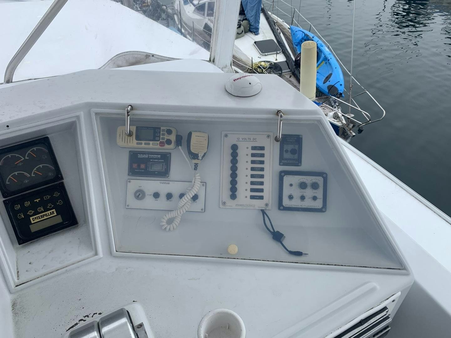 a white boat with a blue sail aboard REHAB Yacht for Sale