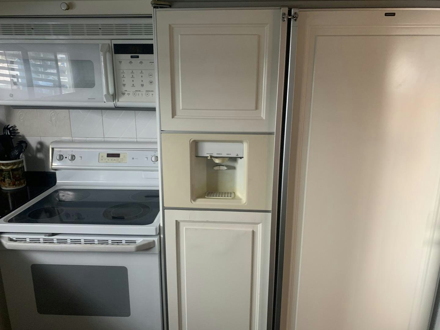 a white refrigerator next to a white microwave oven aboard REHAB Yacht for Sale