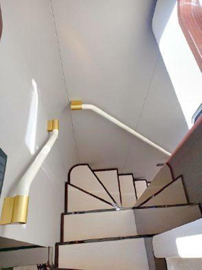a white staircase with a metal railing aboard NOMAD Yacht for Sale