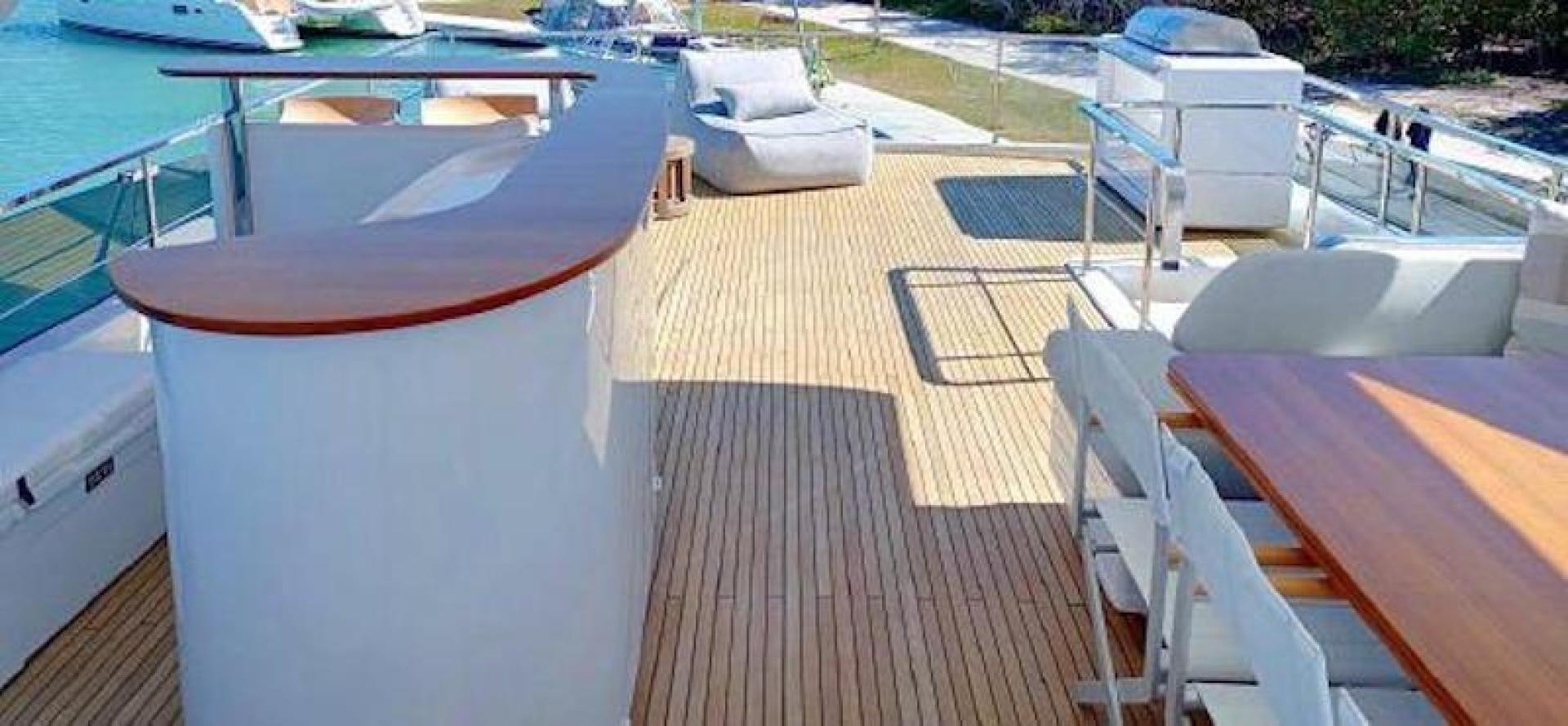 a deck with a table and chairs aboard NOMAD Yacht for Sale