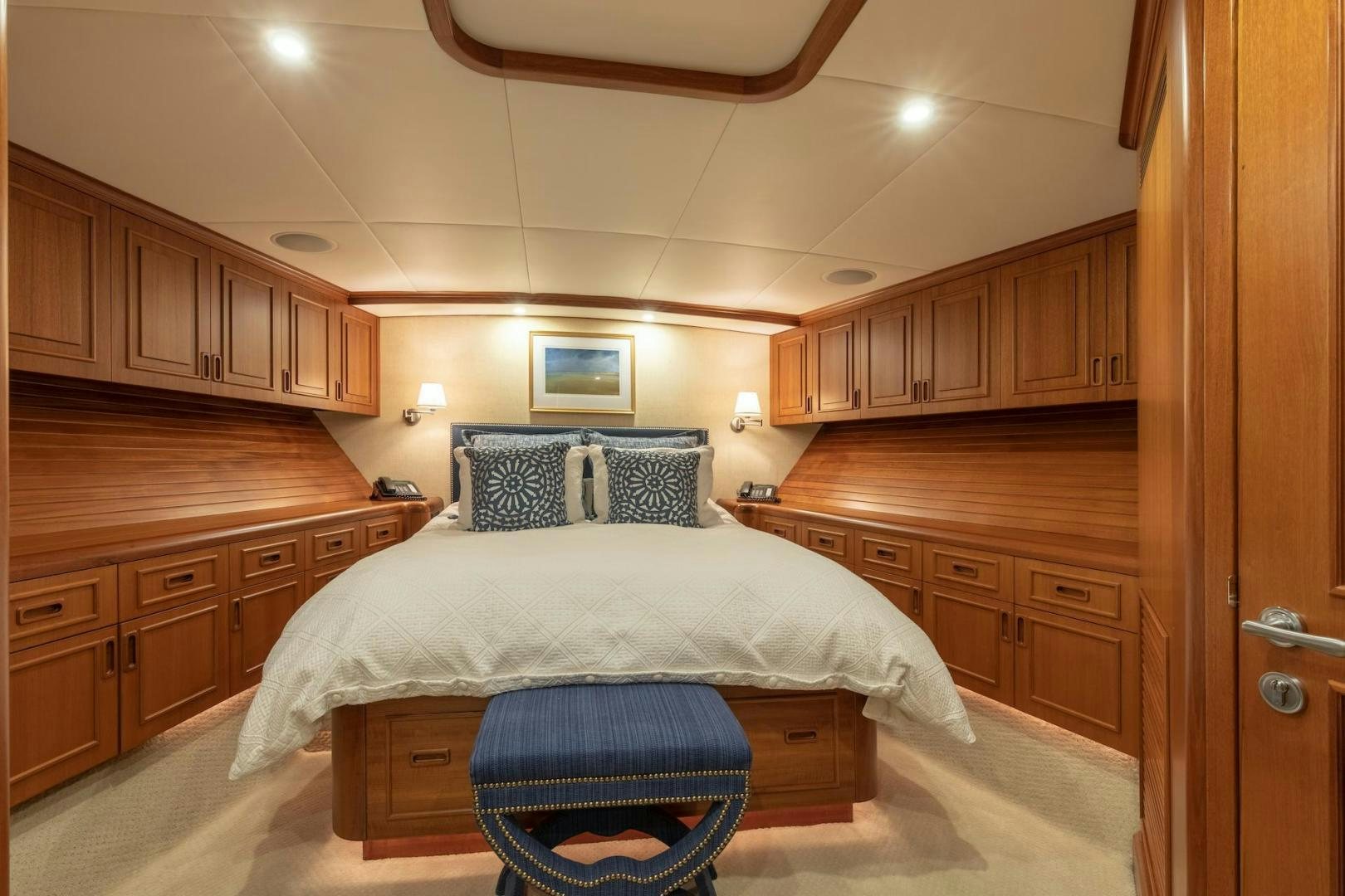 a bedroom with a bed and cabinets aboard CATCH Yacht for Sale