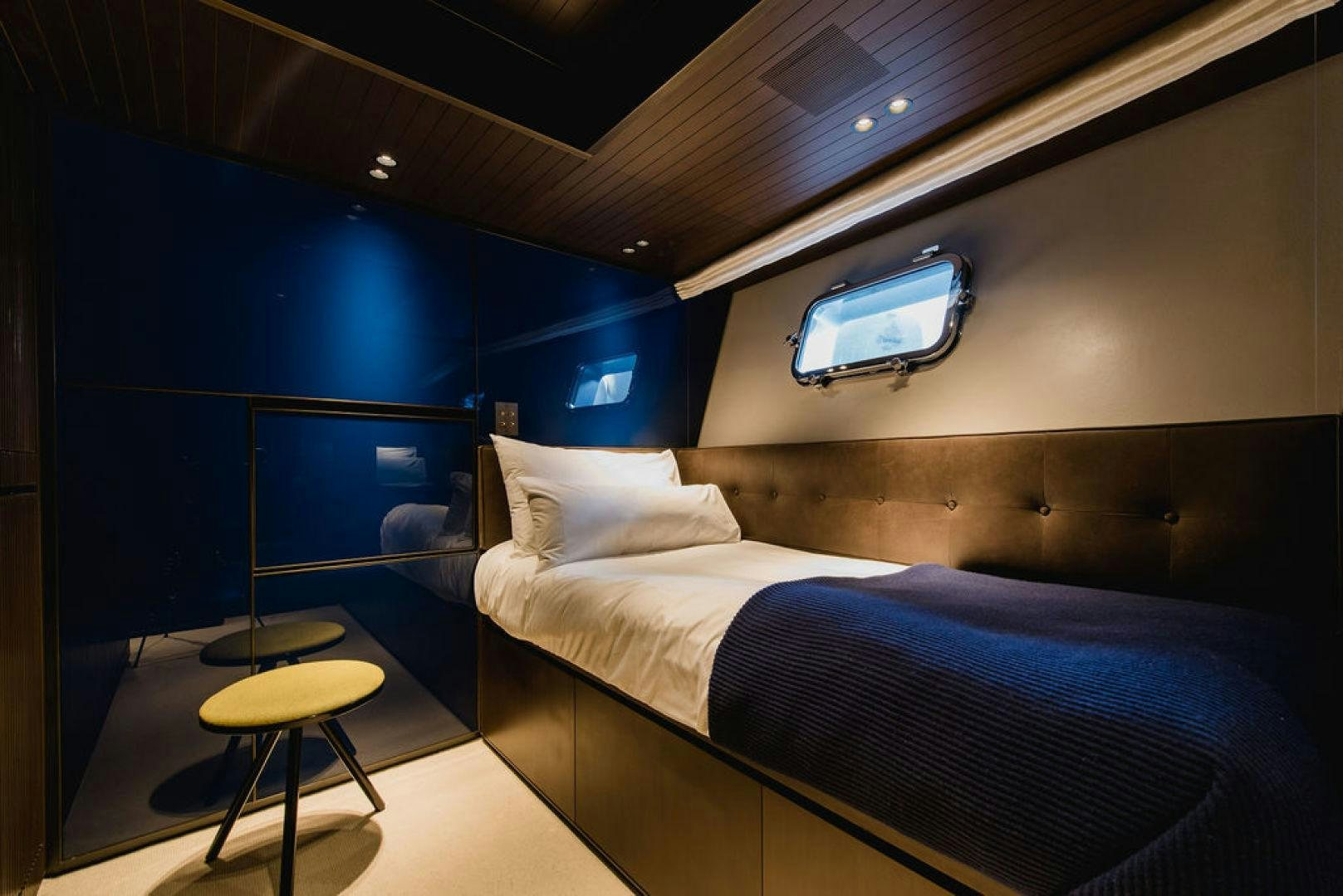 a room with a bed and stools aboard ZAZZAZU II Yacht for Sale