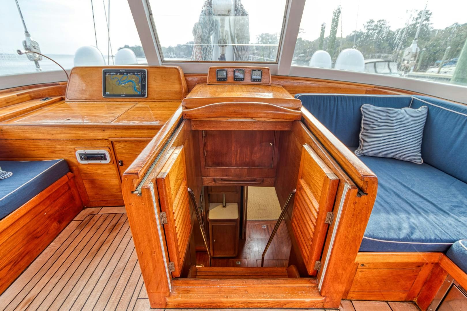 a wooden boat with a bed and a blue couch aboard ARIA Yacht for Sale