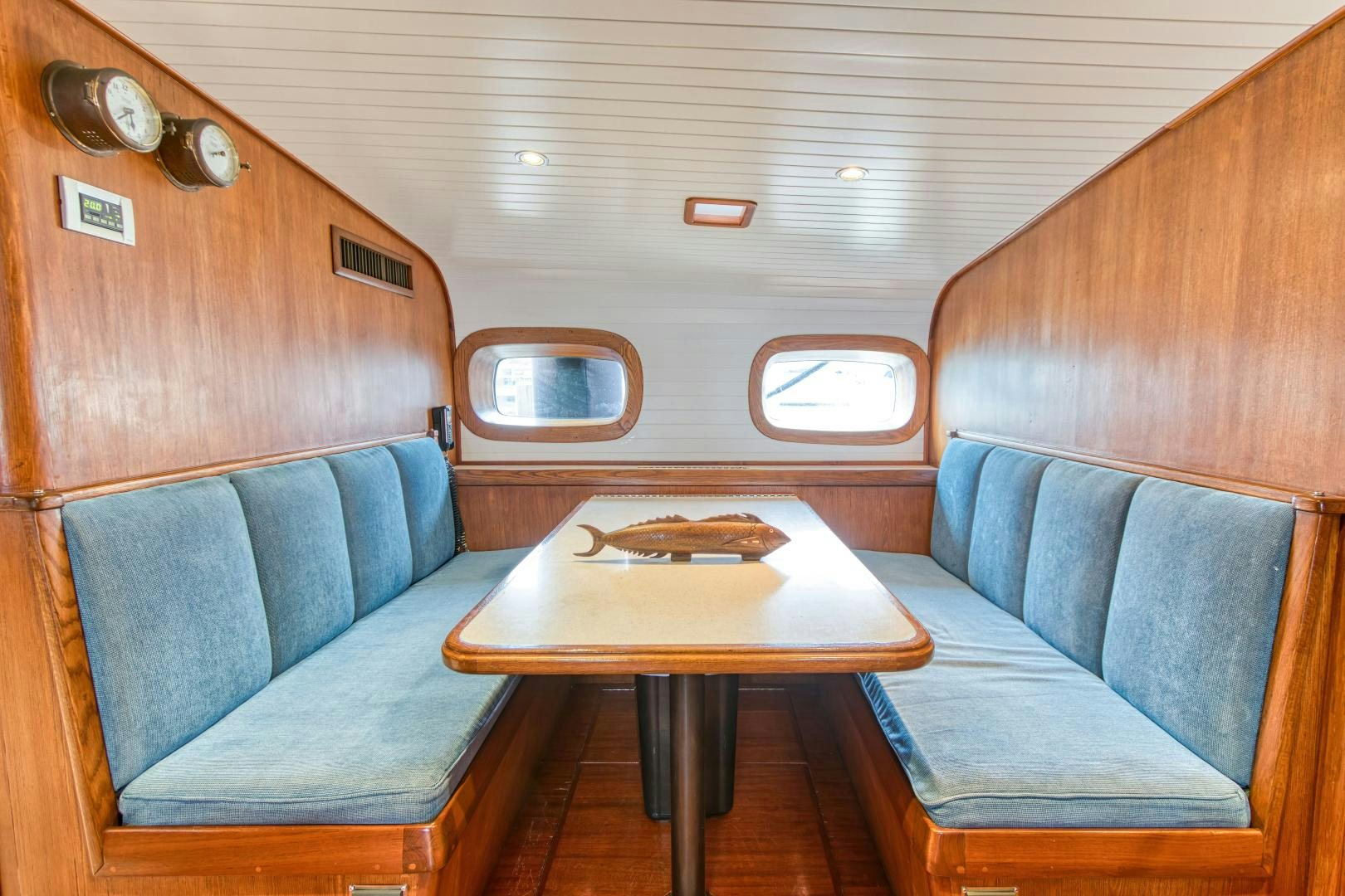 a cabin with a table and couch aboard ARIA Yacht for Sale