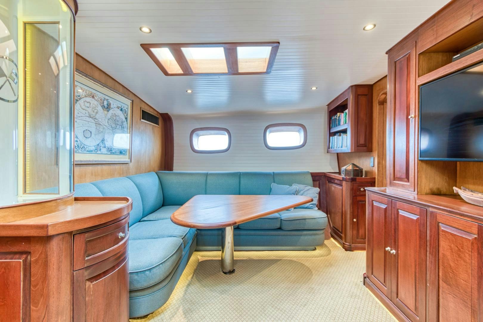 a living room with a blue couch aboard ARIA Yacht for Sale