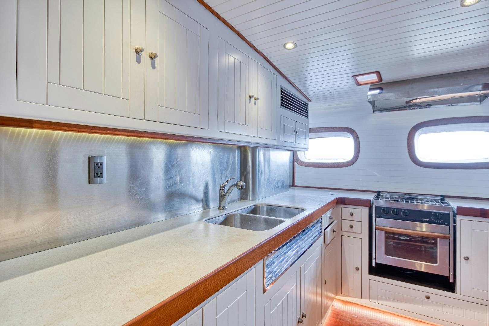 a kitchen with white cabinets aboard ARIA Yacht for Sale