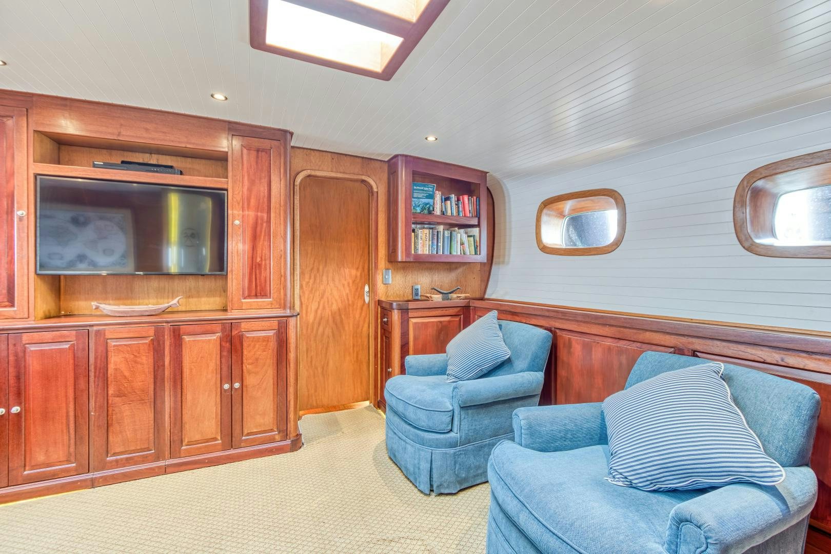 a living room with a couch and a television aboard ARIA Yacht for Sale
