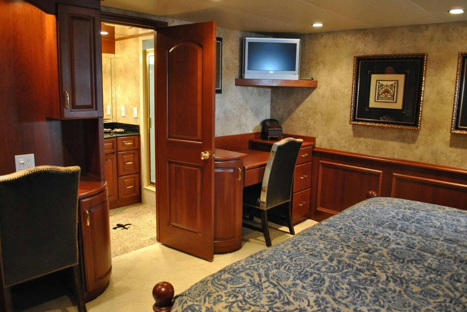 a bedroom with a bed and a television aboard JENNY LYNNE Yacht for Sale