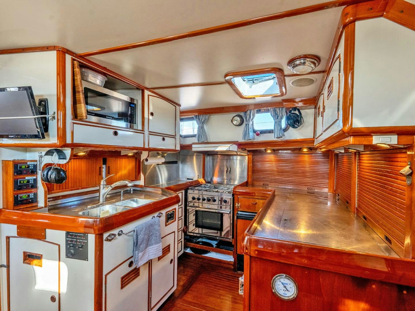 a kitchen with wooden cabinets aboard HERMIE LOUISE Yacht for Sale