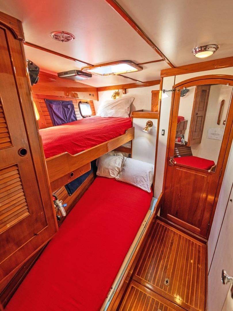 a room with a bed and a mirror aboard HERMIE LOUISE Yacht for Sale
