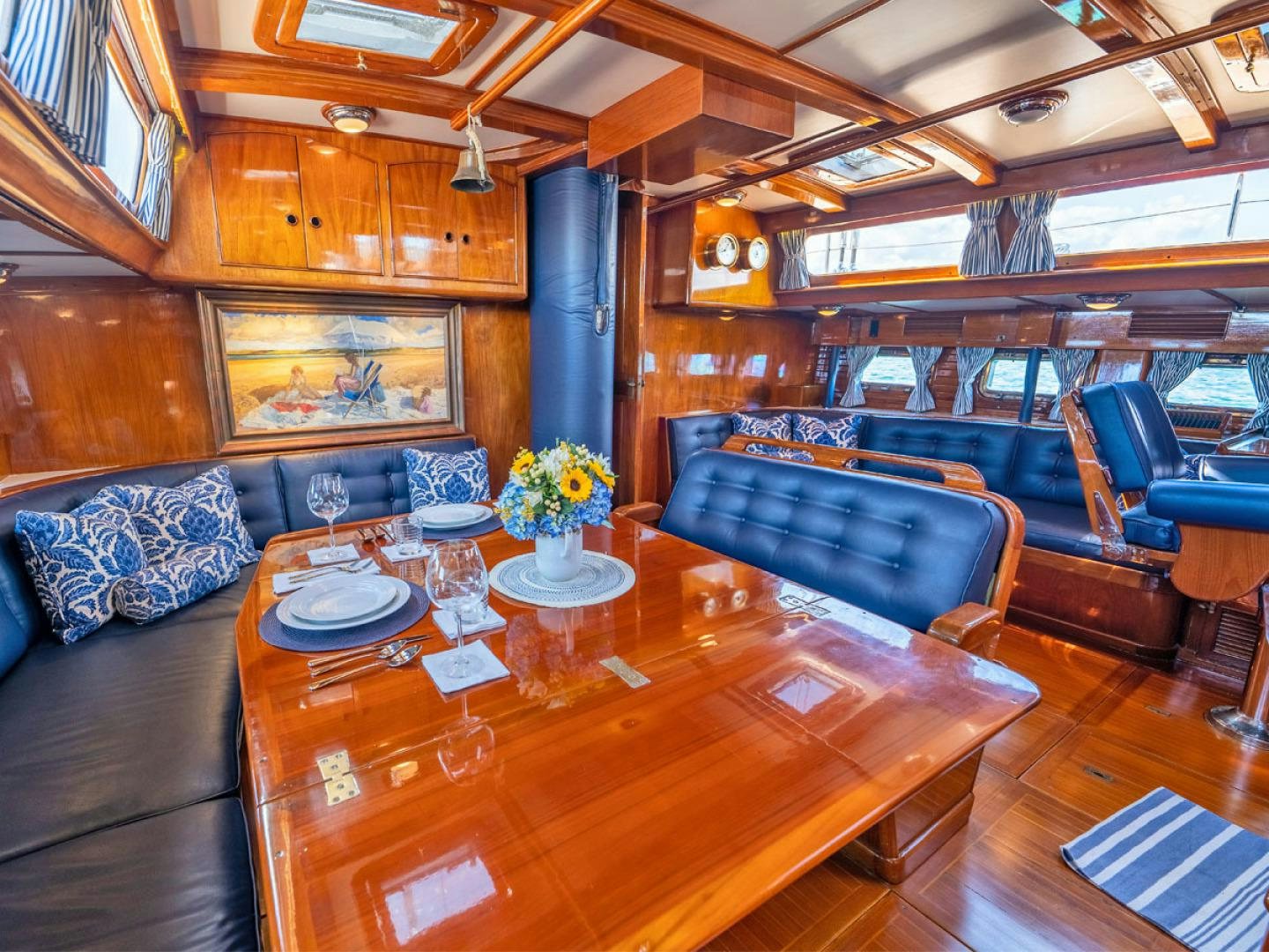 a room with a wood table and couches aboard HERMIE LOUISE Yacht for Sale