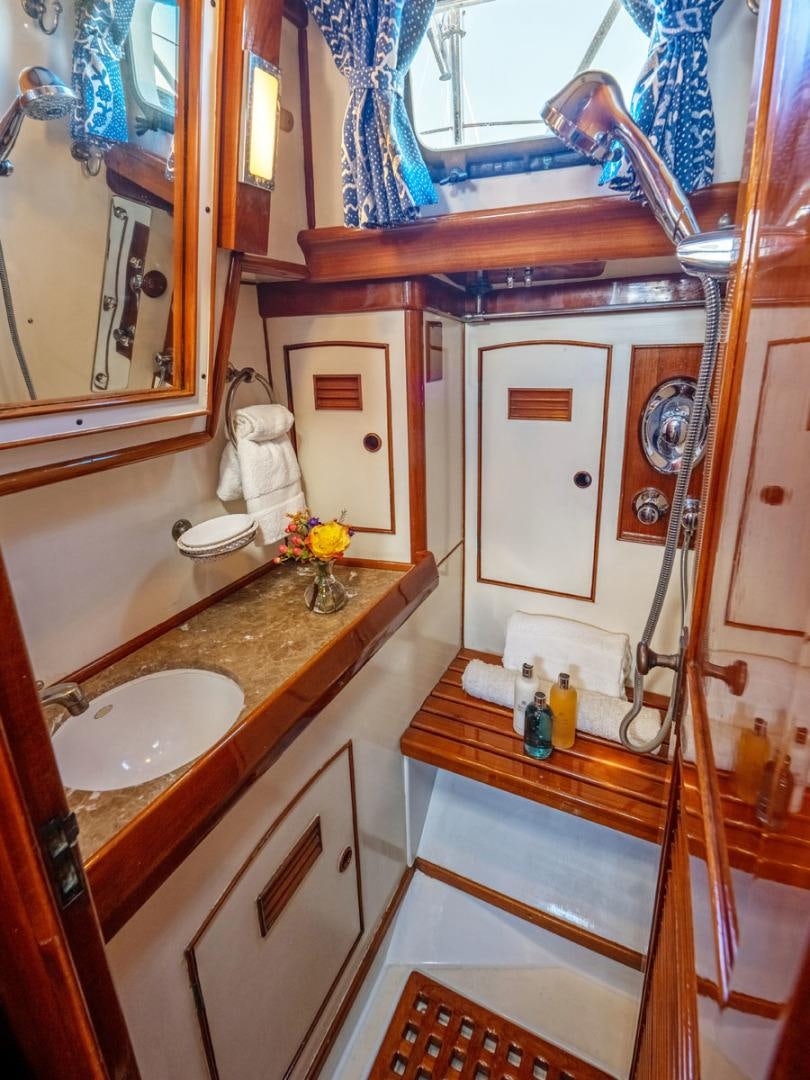 a bathroom with a sink and a mirror aboard HERMIE LOUISE Yacht for Sale