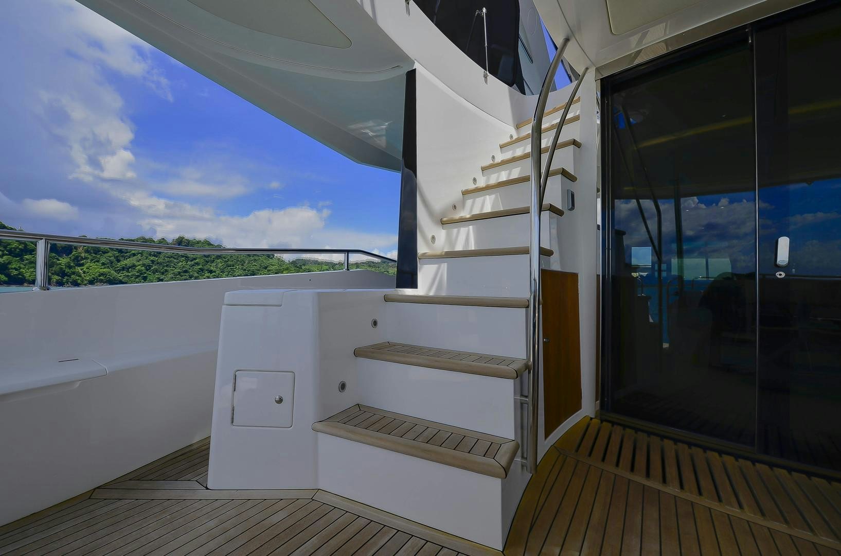 a white room with a wood floor and a window with a view of trees and blue sky aboard PURA VIDA Yacht for Sale