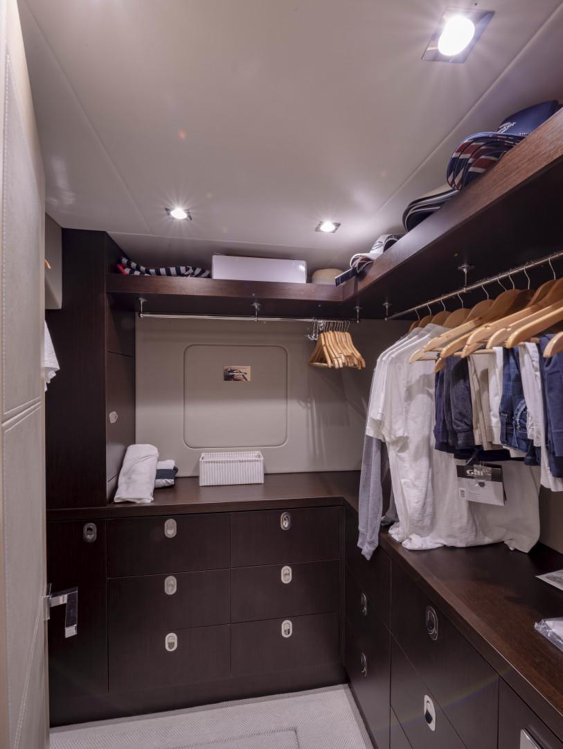 a closet with clothes on the wall aboard PURA VIDA Yacht for Sale