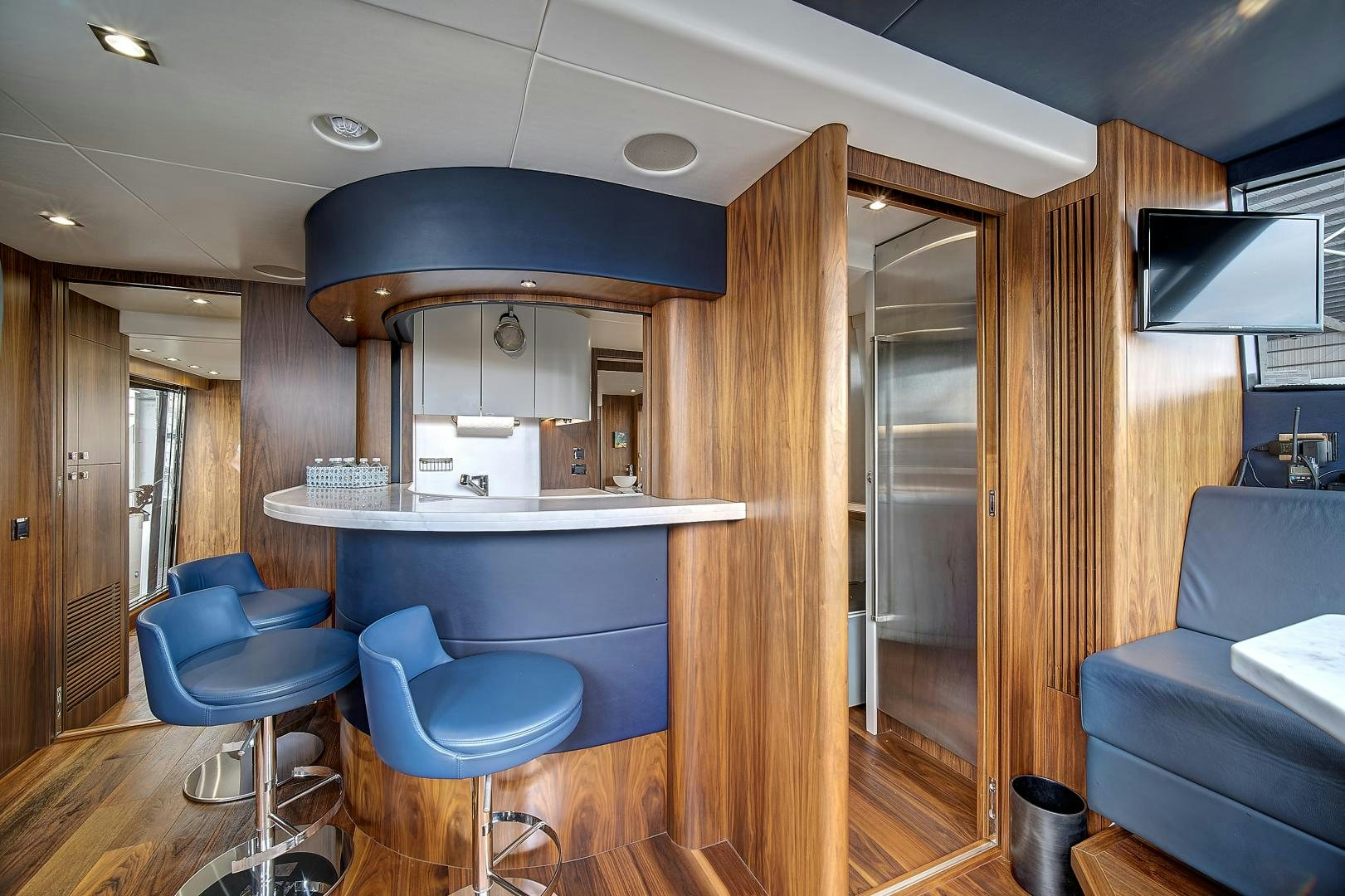 a room with a wood floor and a blue chair and a wood door aboard 'S NOON SOMEWHERE Yacht for Sale