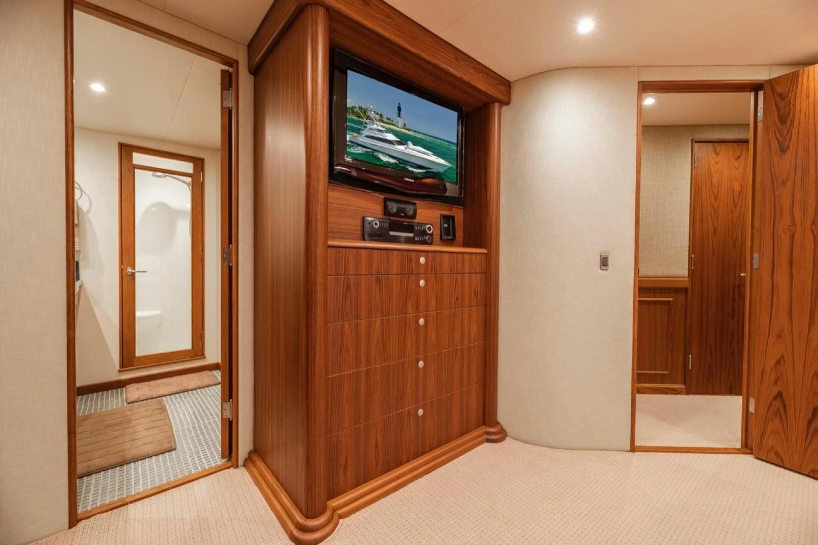 a tv on a stand in a room with wood cabinets aboard DESTINY Yacht for Sale