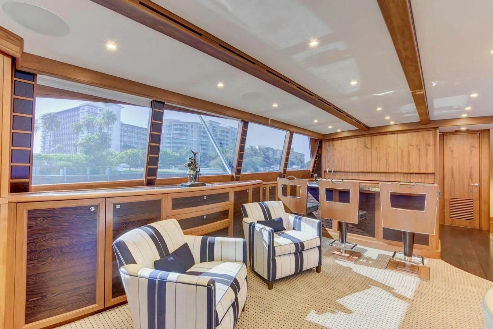 a large living room with wood cabinets aboard III AMIGOS Yacht for Sale