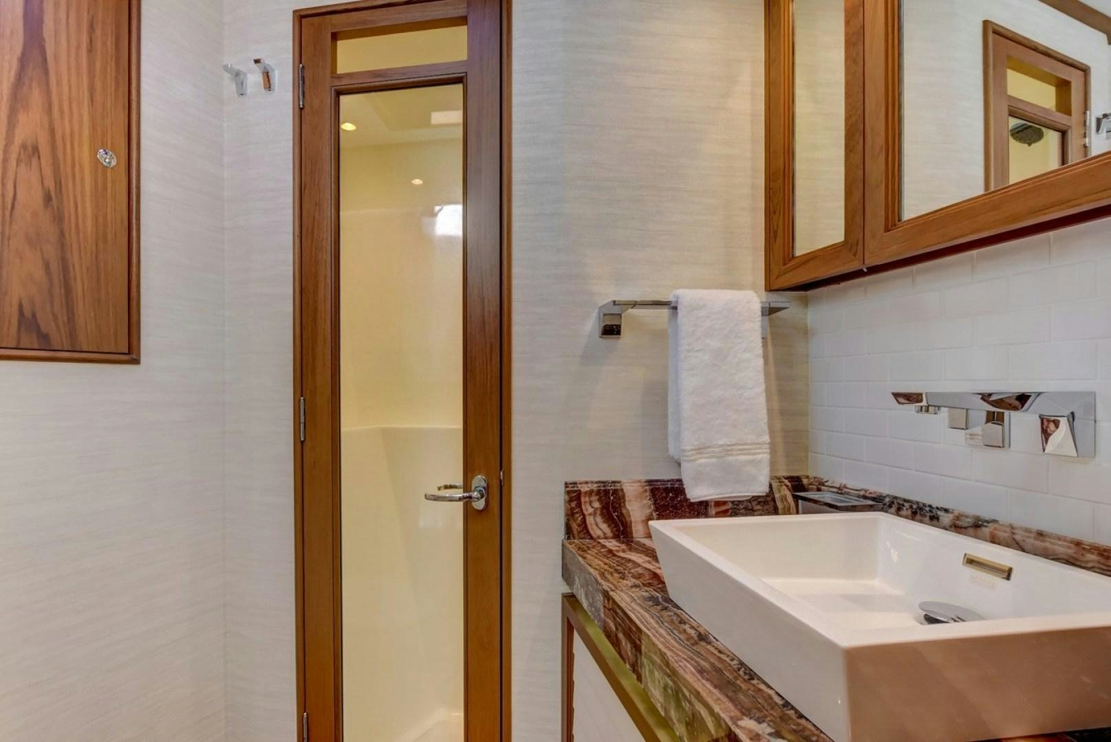 a bathroom with a countertop sink and mirror aboard III AMIGOS Yacht for Sale