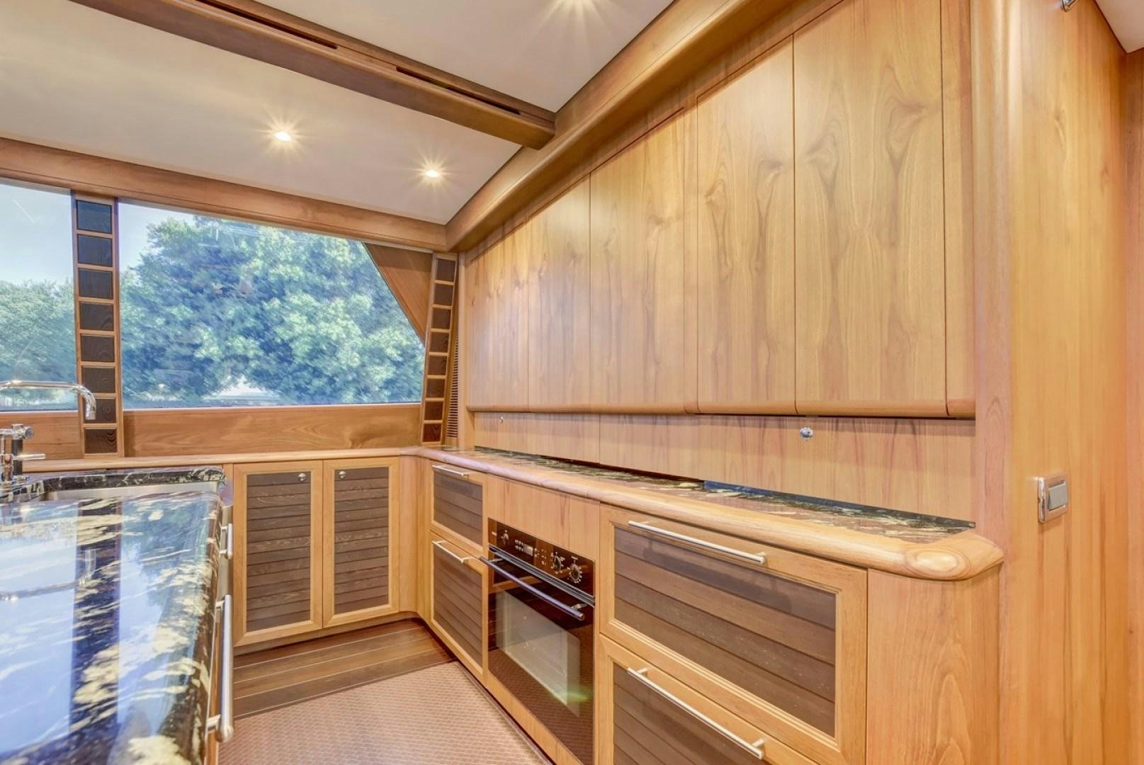 a kitchen with wooden cabinets aboard III AMIGOS Yacht for Sale