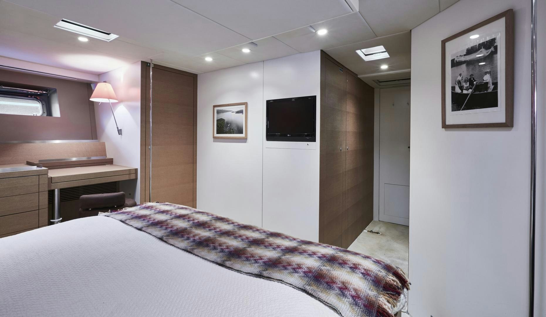 a bedroom with a bed and a television aboard CAPRICHO II Yacht for Sale