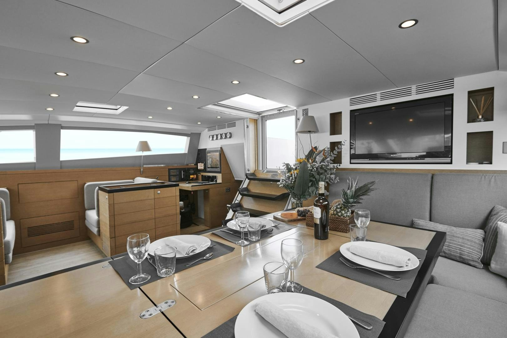 a large living room with a large table and chairs aboard CAPRICHO II Yacht for Sale