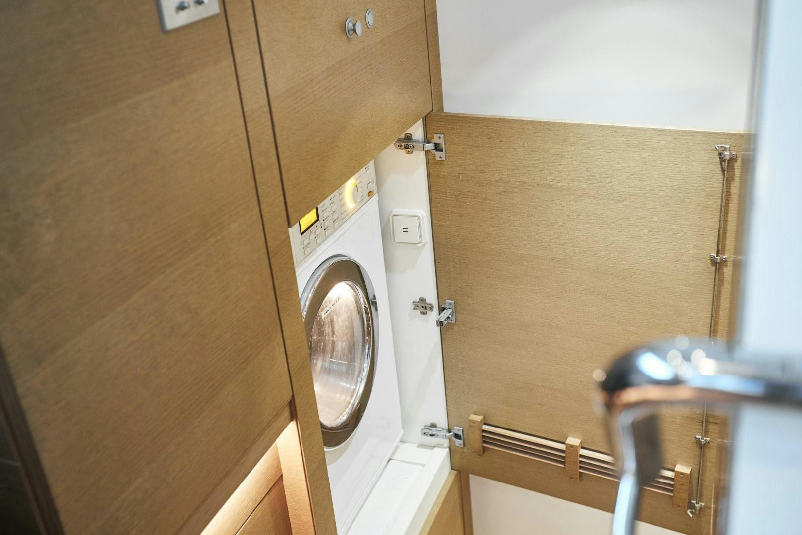 a room with a washing machine and a chair aboard CAPRICHO II Yacht for Sale