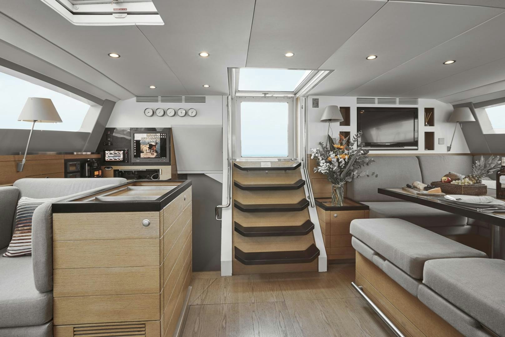 a living room with a wood floor aboard CAPRICHO II Yacht for Sale