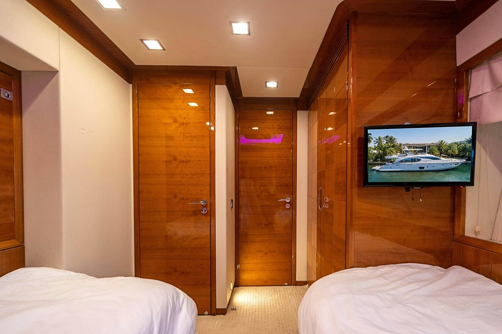 a room with a bed and a television aboard Blue Yacht for Sale