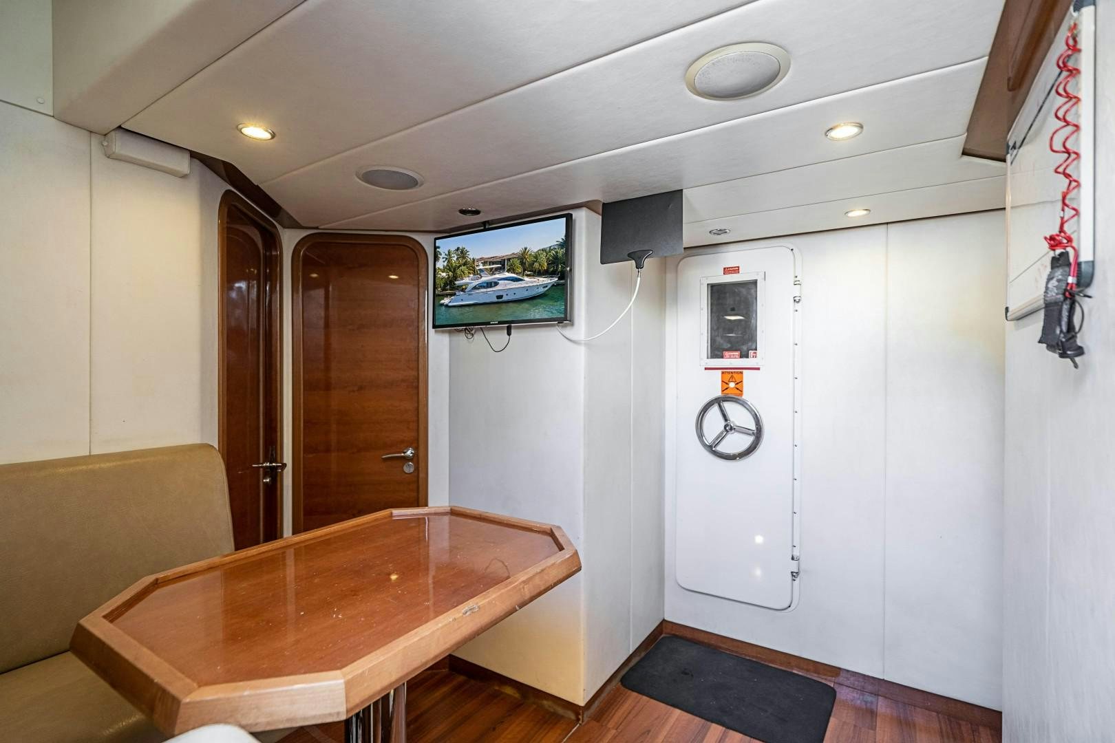 a room with a table and a couch aboard Blue Yacht for Sale