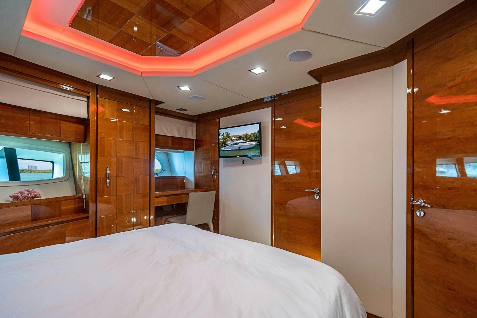 a room with a bed and a television aboard Blue Yacht for Sale