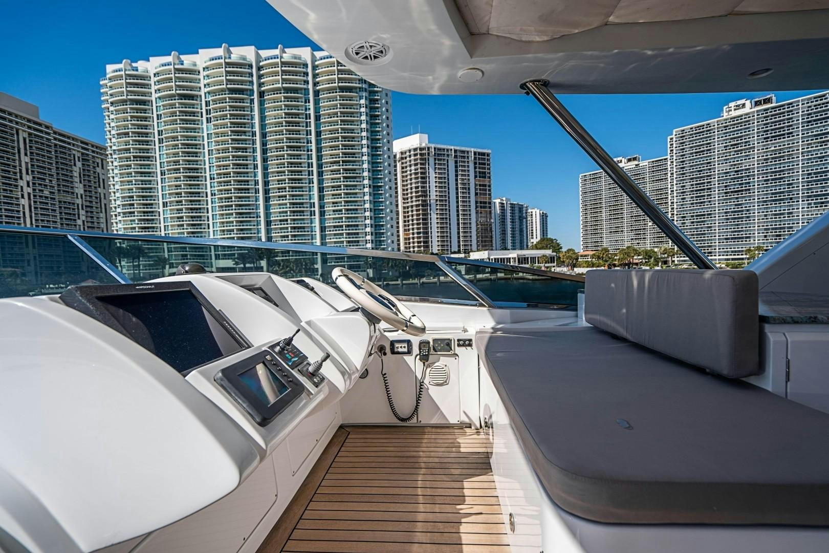 a deck with a boat and a city in the background aboard Blue Yacht for Sale