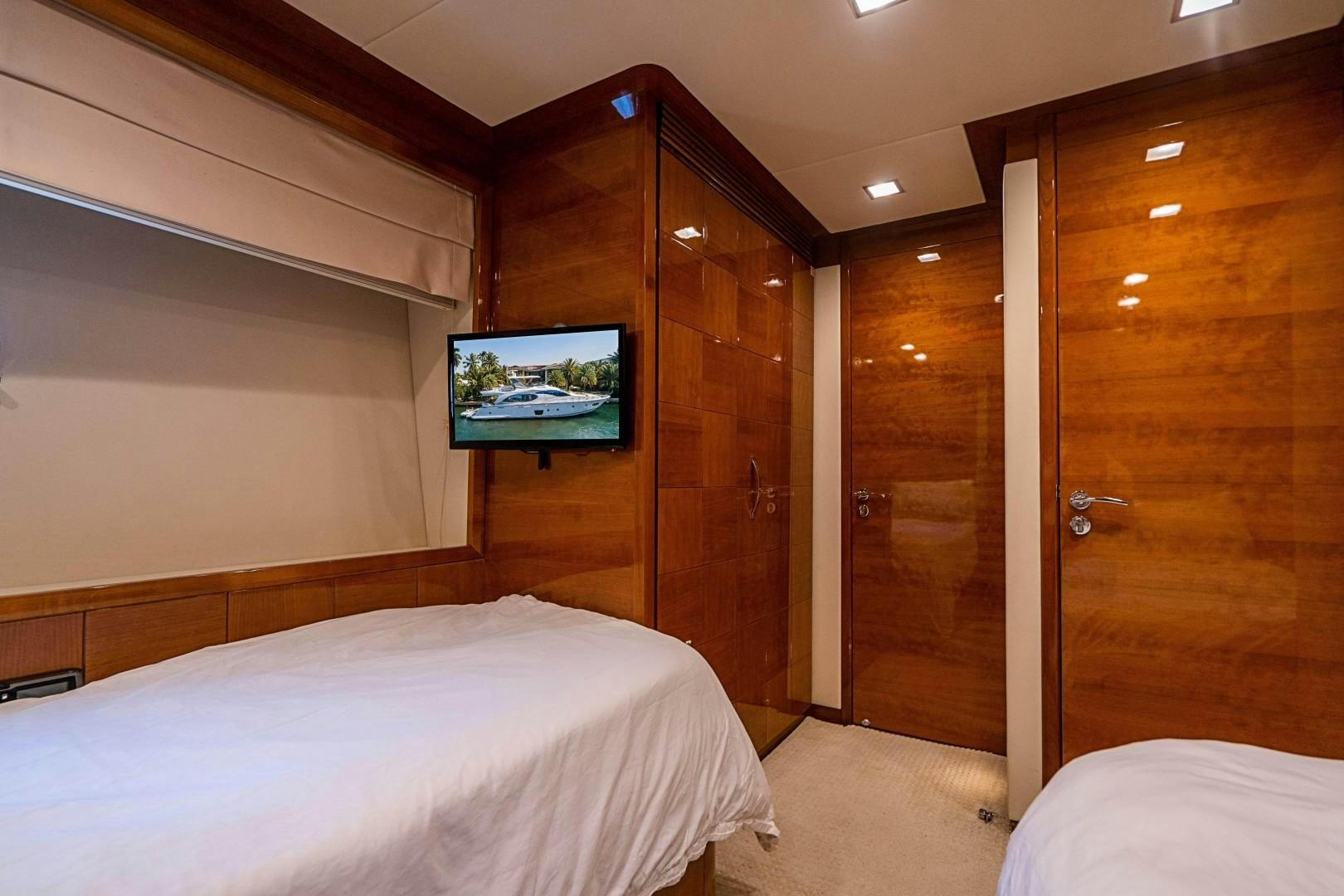 a bedroom with a tv on the wall aboard Blue Yacht for Sale