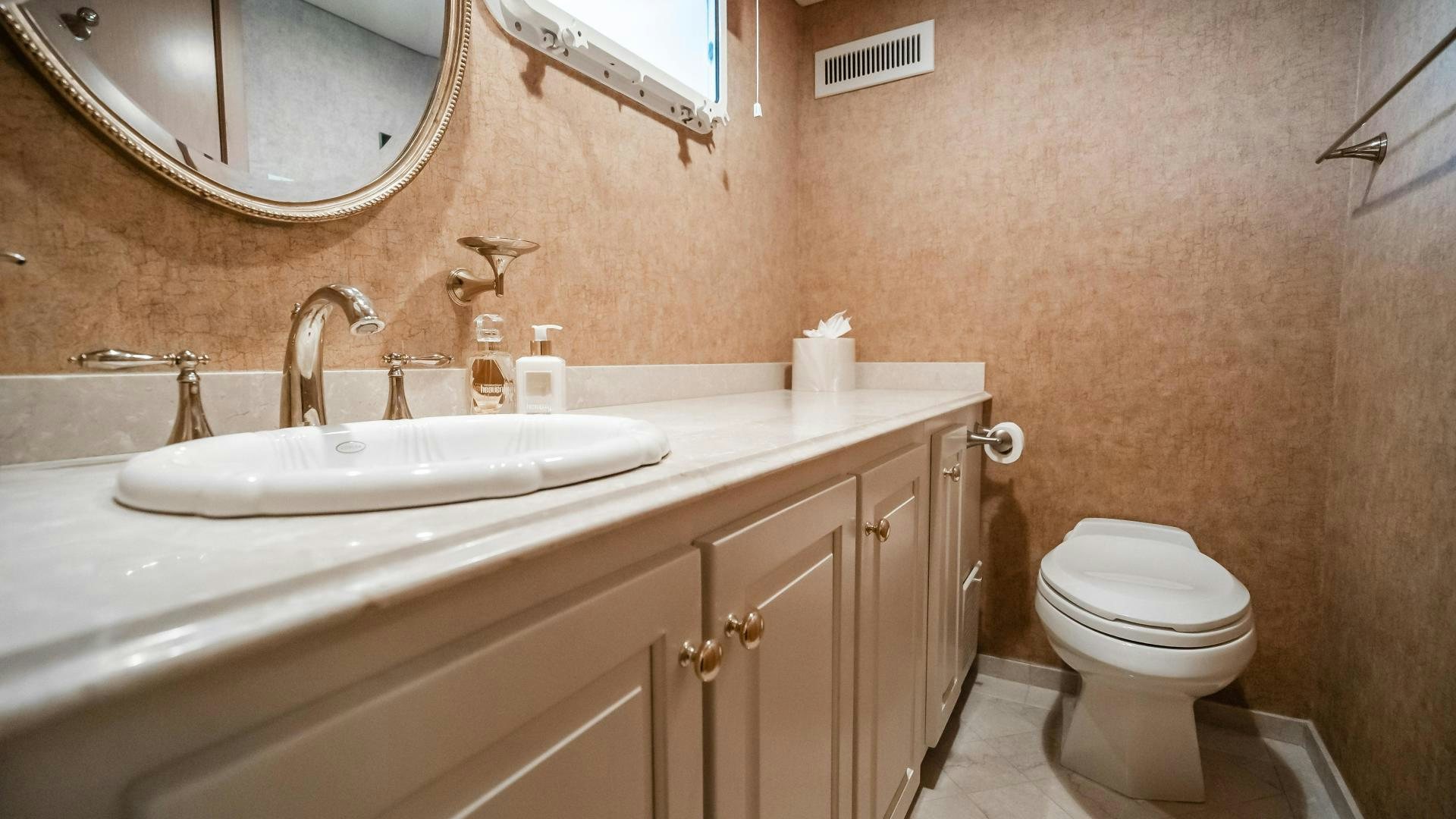 a bathroom with a toilet sink and a mirror aboard COME MONDAY Yacht for Sale