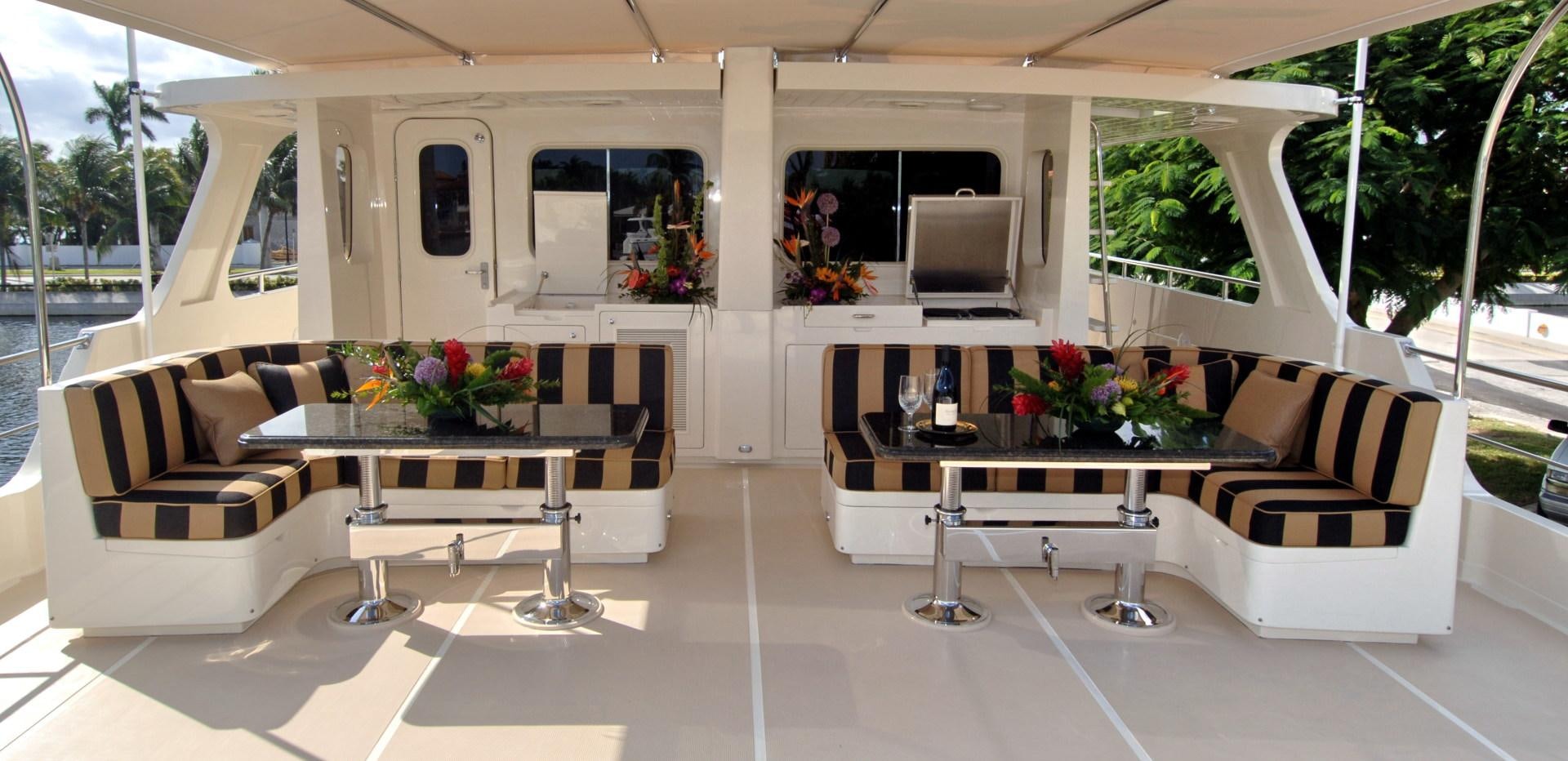 a room with a table and couches aboard No Name Yacht for Sale