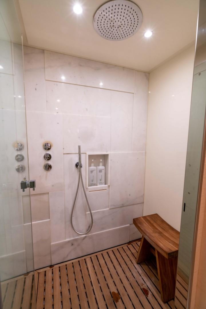 a shower with a sink and a wooden bench aboard PHOENIX Yacht for Sale