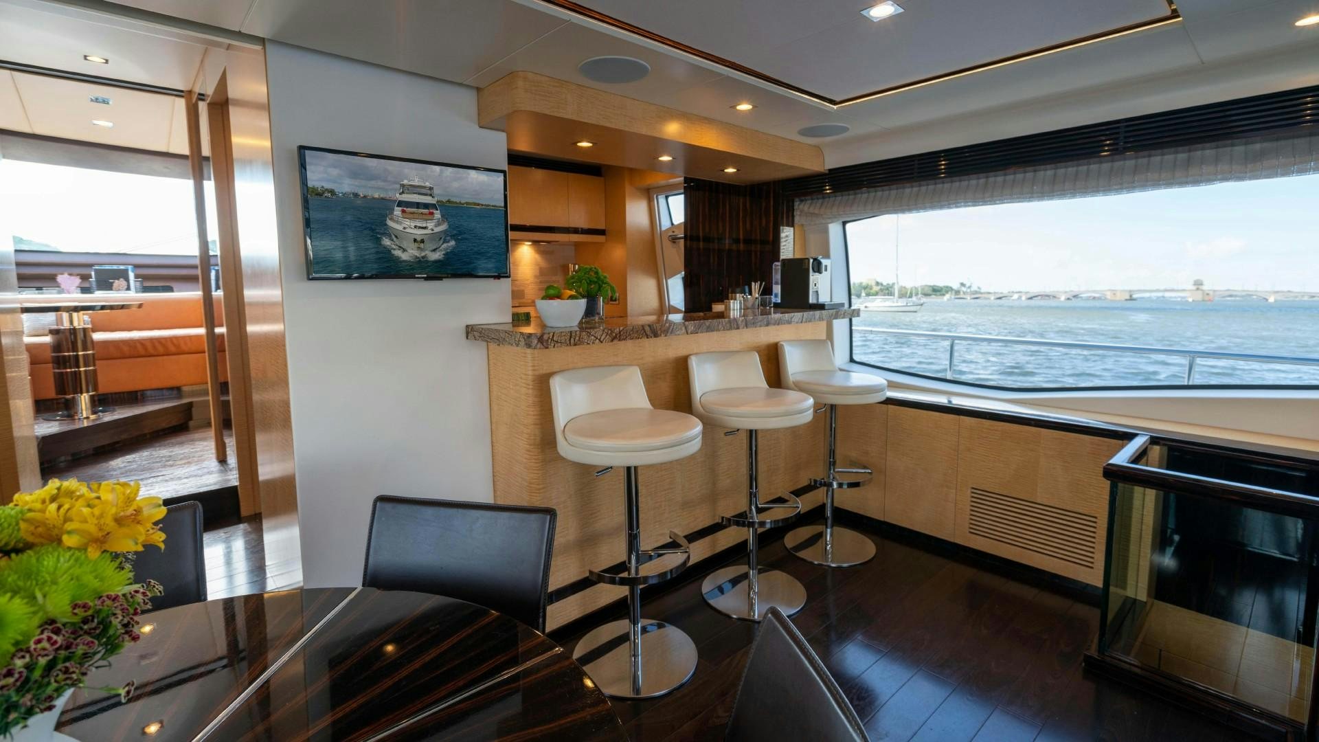a room with a table chairs and a view of the ocean aboard PHOENIX Yacht for Sale