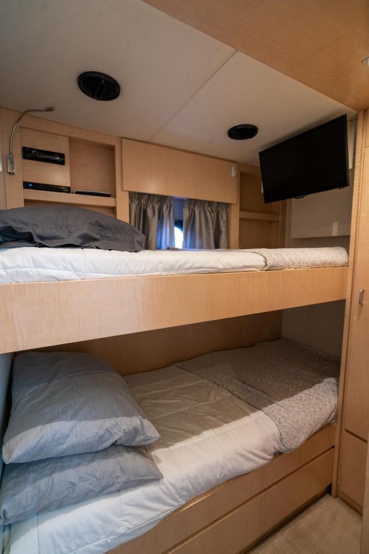 a room with a bed and a television aboard PHOENIX Yacht for Sale