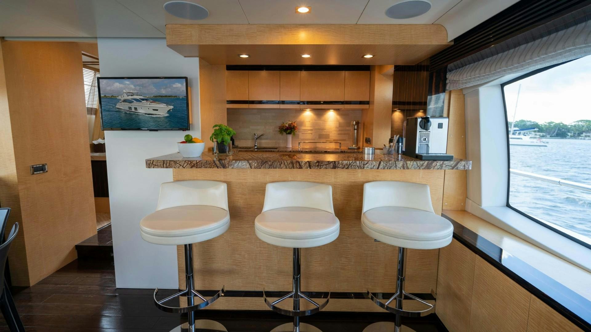 a kitchen with a bar and stools aboard PHOENIX Yacht for Sale