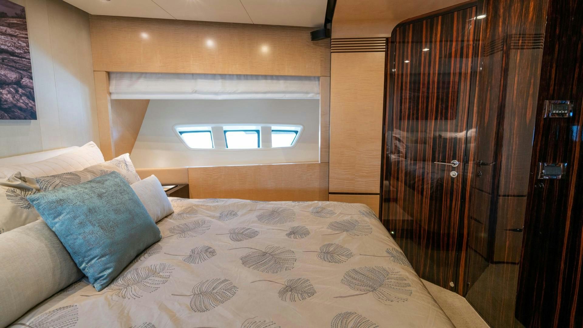 a bed with a blue pillow aboard PHOENIX Yacht for Sale