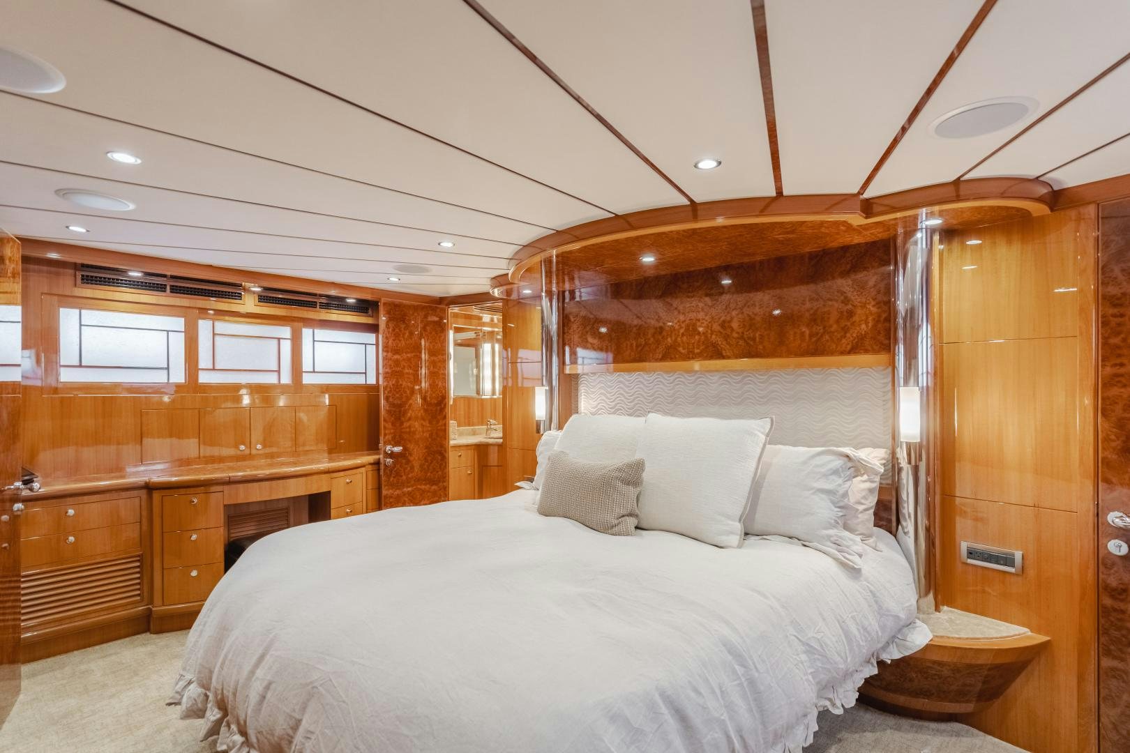 a bedroom with a bed and a wood cabinet aboard OBSESSION Yacht for Sale