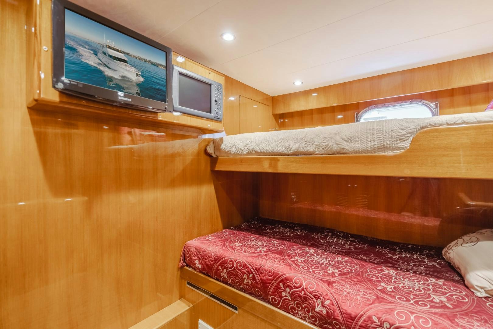 a room with a tv and a bed aboard OBSESSION Yacht for Sale