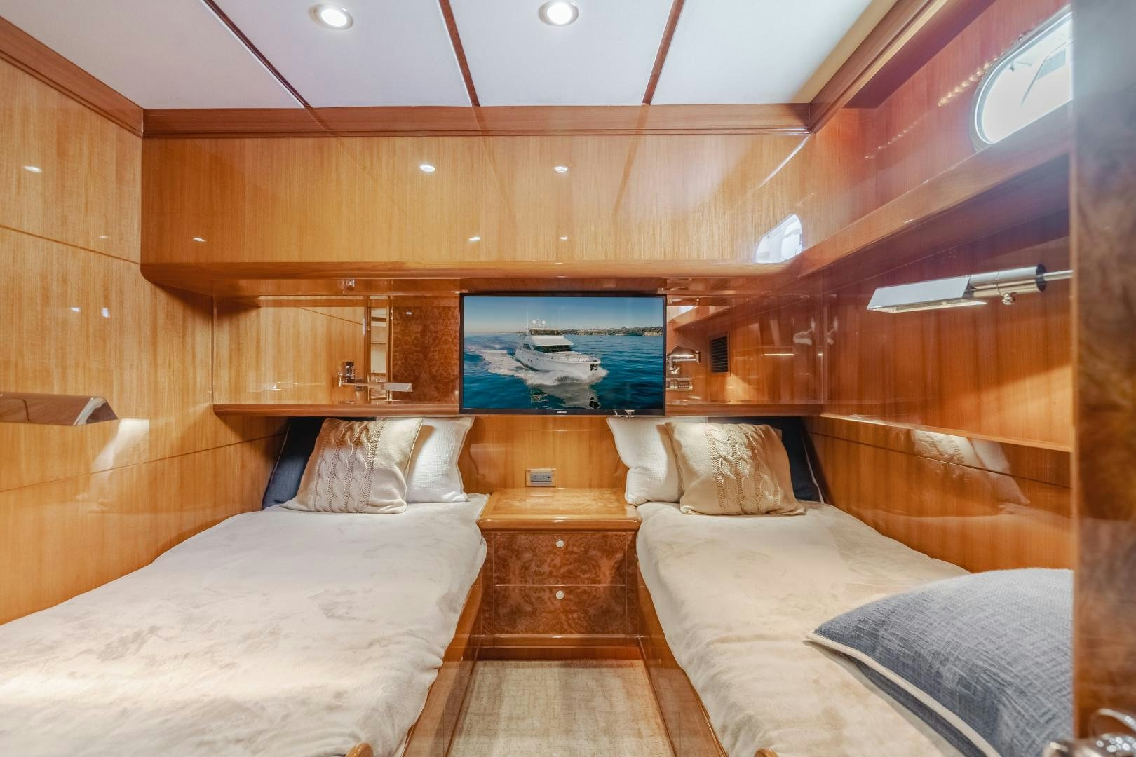 a room with a bed and a television aboard OBSESSION Yacht for Sale