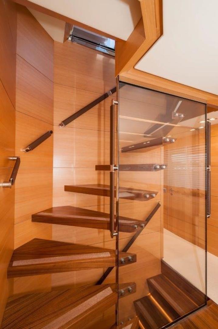 a wooden staircase with glass doors aboard NEVER REST Yacht for Sale
