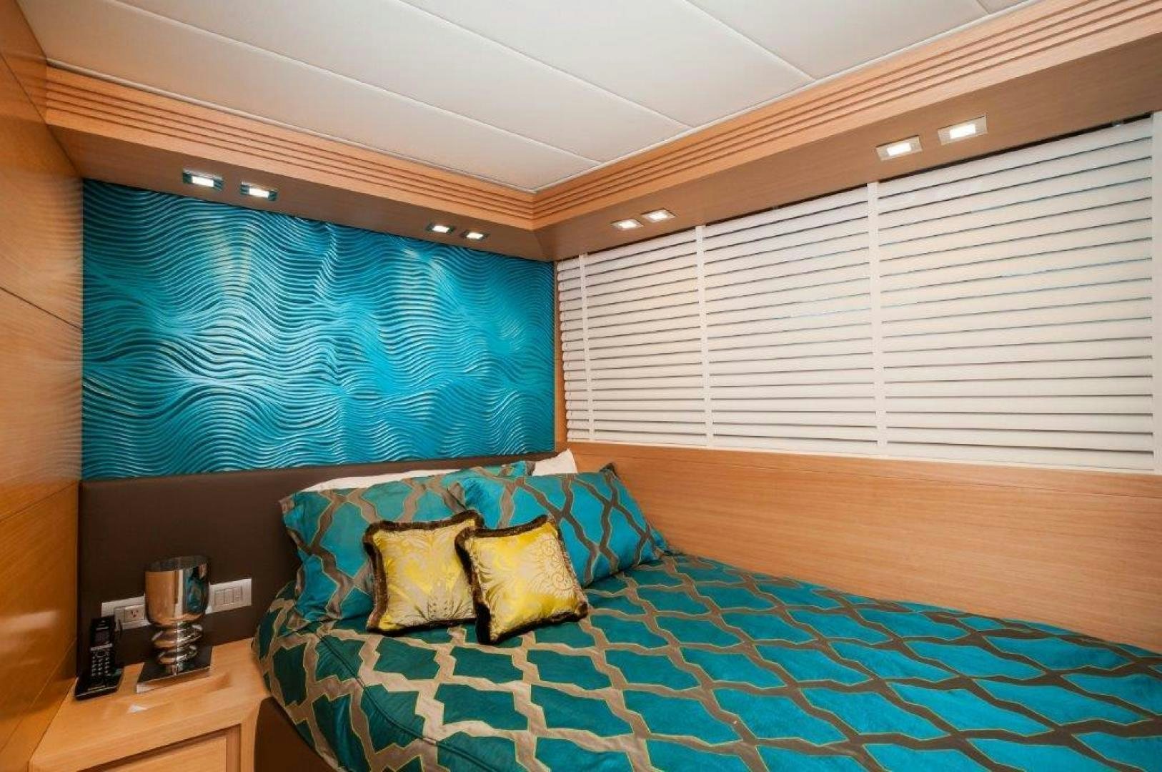 a bed with blue and yellow sheets aboard NEVER REST Yacht for Sale